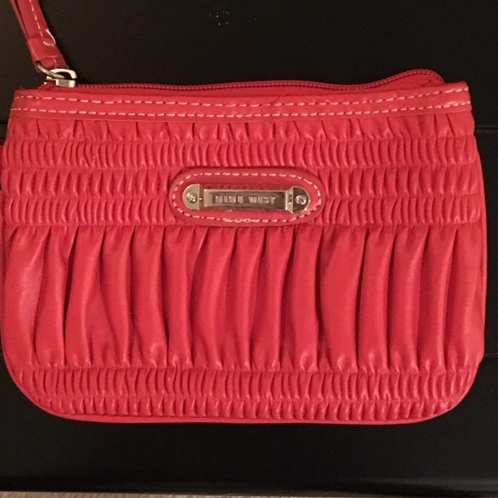 A light red Nine West wristlet